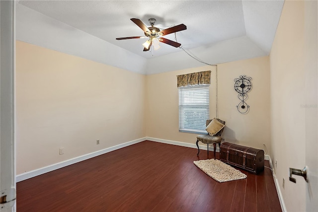 unfurnished room with vaulted ceiling, a raised ceiling, ceiling fan, and dark hardwood / wood-style floors