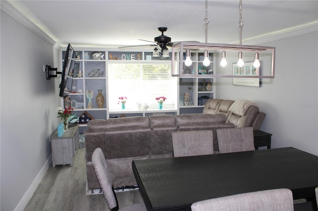 living room with ornamental molding, ceiling fan, baseboards, and wood finished floors