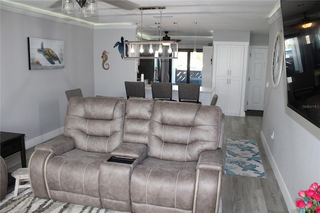 living room with ceiling fan, crown molding, baseboards, and wood finished floors