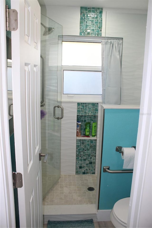 bathroom with toilet and a shower stall