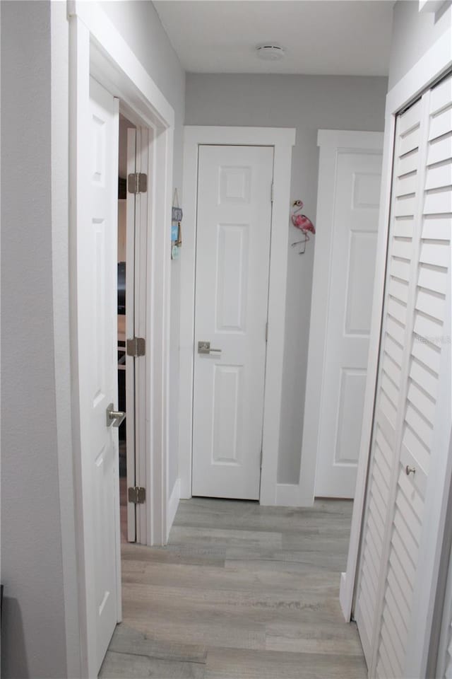 hallway featuring light wood-style floors and baseboards