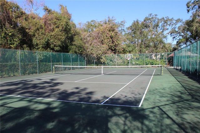 view of tennis court featuring fence