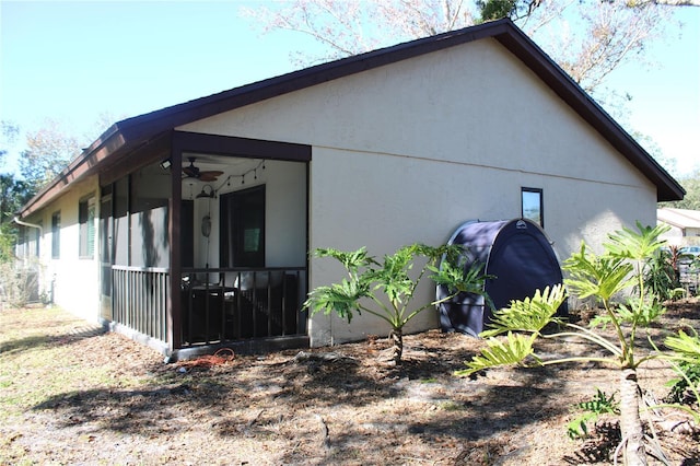 view of home's exterior with a sunroom and stucco siding