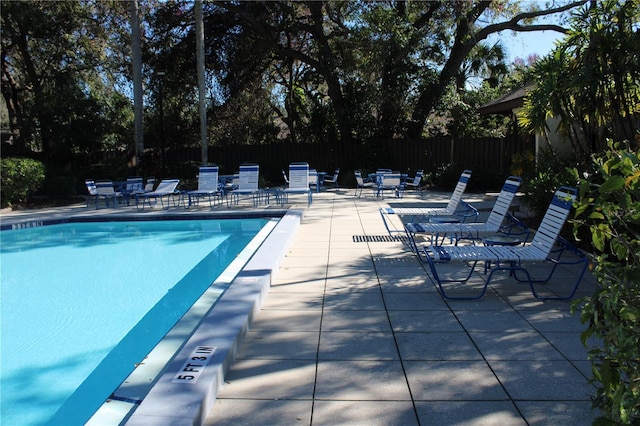 community pool featuring a patio area and fence