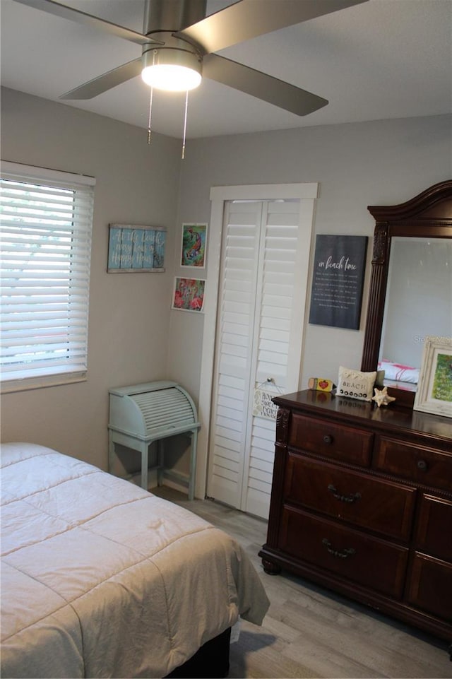 bedroom with a ceiling fan and light wood-style flooring