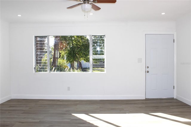 empty room with ceiling fan, dark hardwood / wood-style flooring, and a wealth of natural light