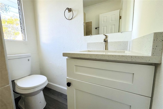 bathroom with hardwood / wood-style flooring, vanity, and toilet