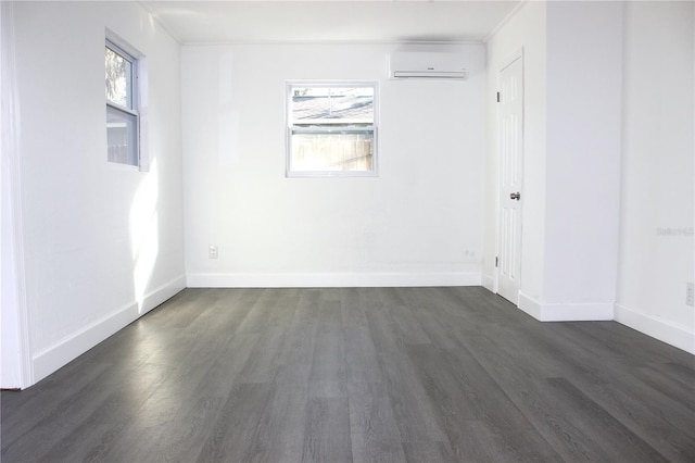 unfurnished room with a wall mounted air conditioner, dark hardwood / wood-style floors, and a wealth of natural light