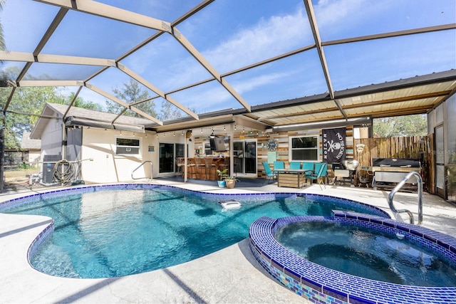 view of swimming pool with an in ground hot tub, a patio, glass enclosure, and exterior bar