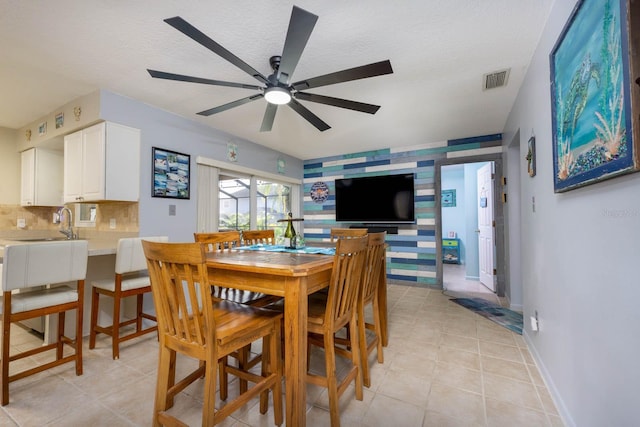 dining area with ceiling fan, light tile patterned flooring, and a textured ceiling