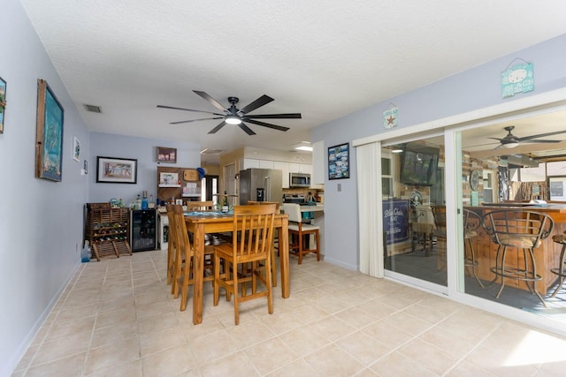 dining area featuring a textured ceiling and wine cooler