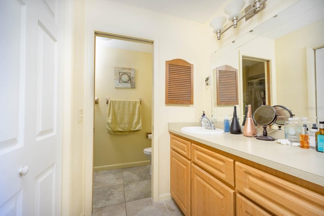 bathroom featuring tile patterned floors, vanity, and toilet