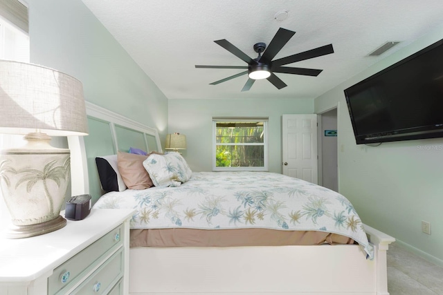 bedroom with ceiling fan and a textured ceiling