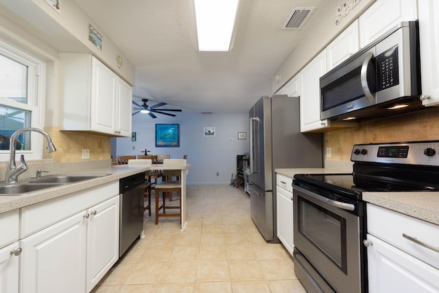 kitchen featuring white cabinets, ceiling fan, sink, and stainless steel appliances