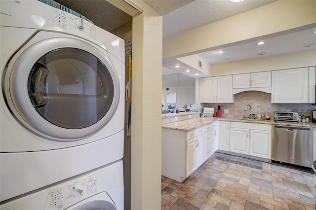 clothes washing area with stacked washer / dryer and sink