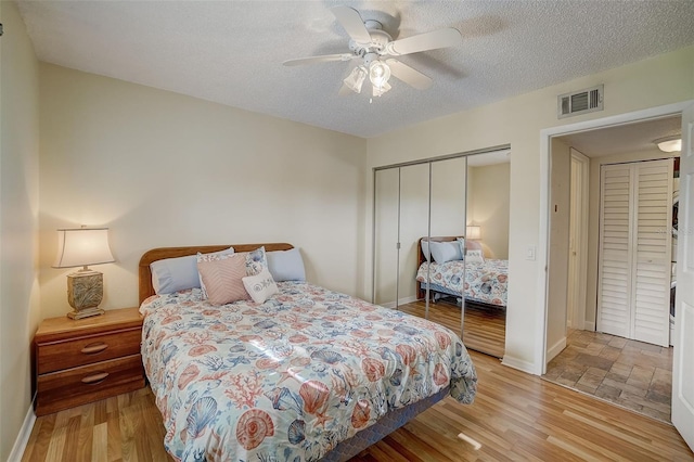 bedroom featuring ceiling fan, light hardwood / wood-style floors, a closet, and a textured ceiling