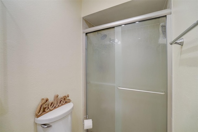 bathroom with toilet and an enclosed shower