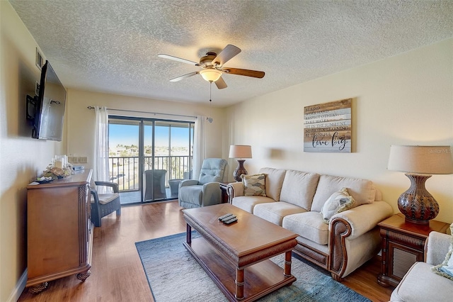 living room with dark hardwood / wood-style floors, a textured ceiling, and ceiling fan