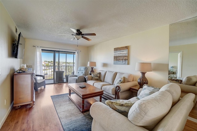 living room with ceiling fan, dark hardwood / wood-style flooring, and a textured ceiling