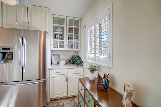 kitchen featuring white cabinets and stainless steel fridge with ice dispenser