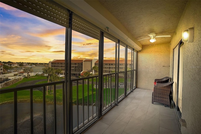 balcony at dusk featuring ceiling fan