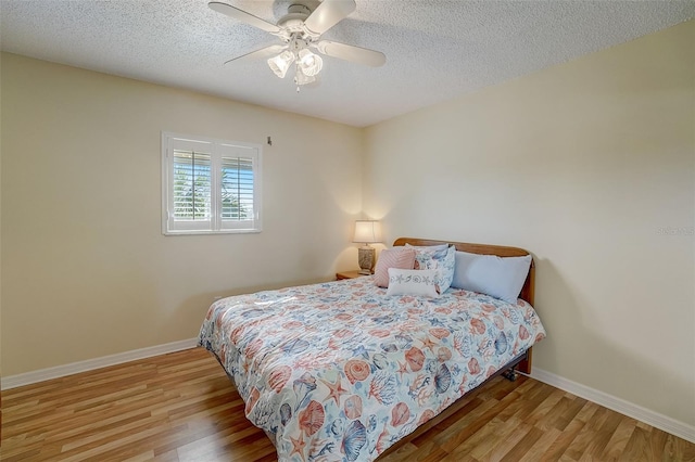 bedroom featuring ceiling fan, a textured ceiling, and light wood-type flooring