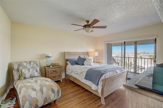 bedroom featuring hardwood / wood-style flooring, ceiling fan, a textured ceiling, and access to outside