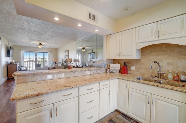 kitchen featuring white cabinetry, sink, and kitchen peninsula