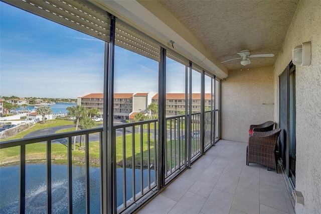 balcony featuring a water view and ceiling fan