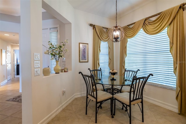 tiled dining area featuring a chandelier