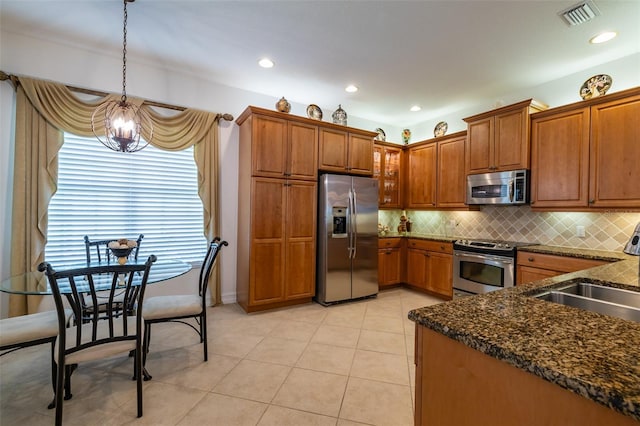 kitchen featuring sink, hanging light fixtures, a notable chandelier, light tile patterned floors, and appliances with stainless steel finishes