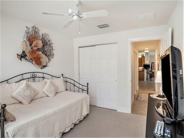 bedroom featuring light colored carpet, a closet, and ceiling fan