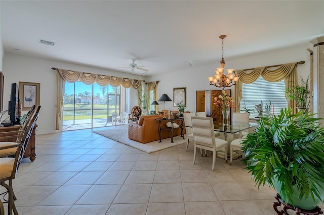 living room with light tile patterned floors and ceiling fan with notable chandelier