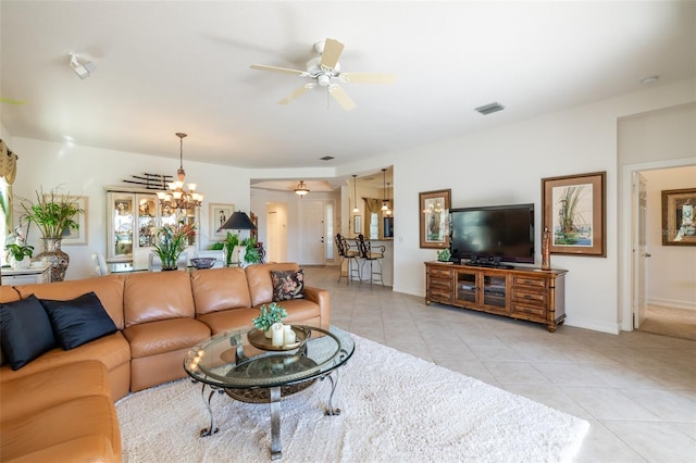 living room featuring ceiling fan with notable chandelier and light tile patterned floors