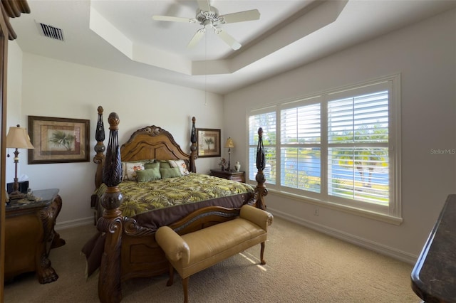 bedroom featuring carpet flooring, ceiling fan, and a tray ceiling