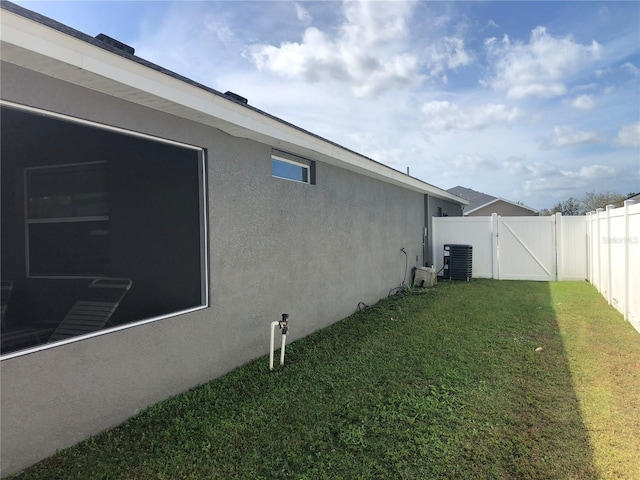 view of side of property with a yard and cooling unit