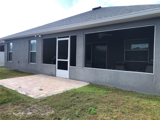 rear view of property featuring a patio area, a sunroom, and a yard