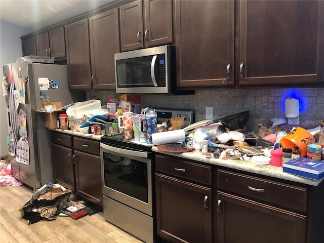 kitchen featuring decorative backsplash, dark brown cabinetry, stainless steel appliances, and light hardwood / wood-style floors