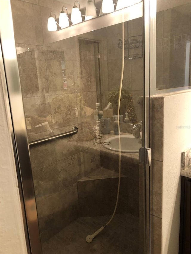 bathroom featuring a shower with door and vanity