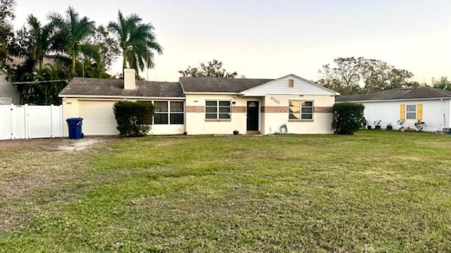 ranch-style house with a front yard and a garage