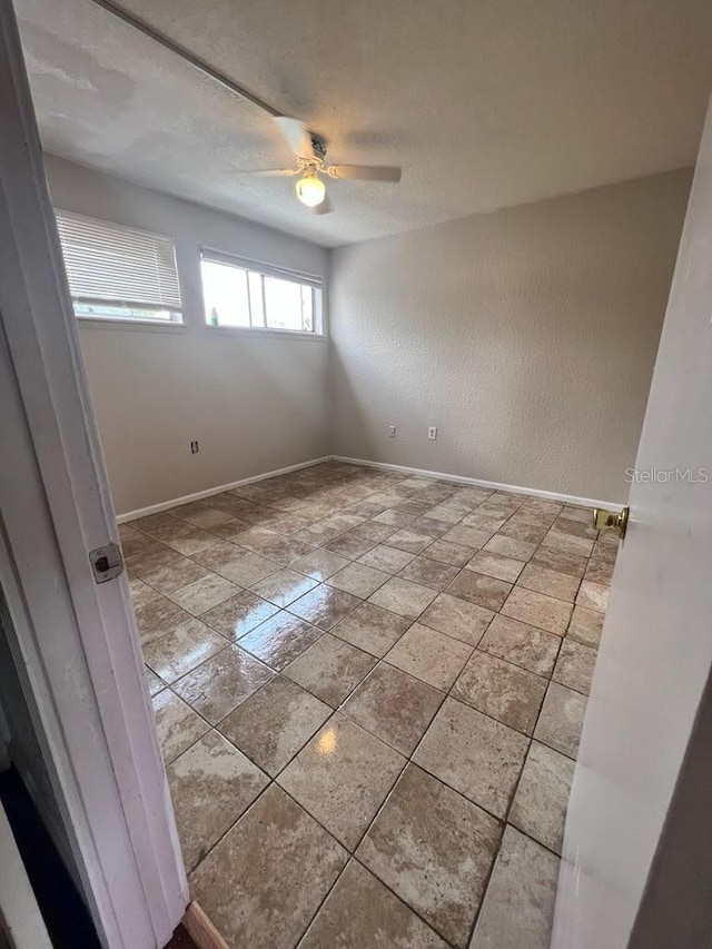 spare room featuring a textured ceiling and ceiling fan