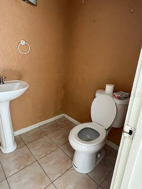 bathroom with sink, tile patterned flooring, and toilet