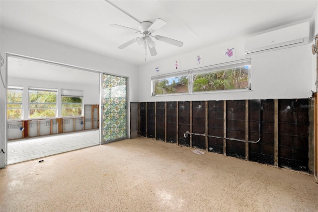 empty room featuring plenty of natural light, a wall unit AC, and ceiling fan