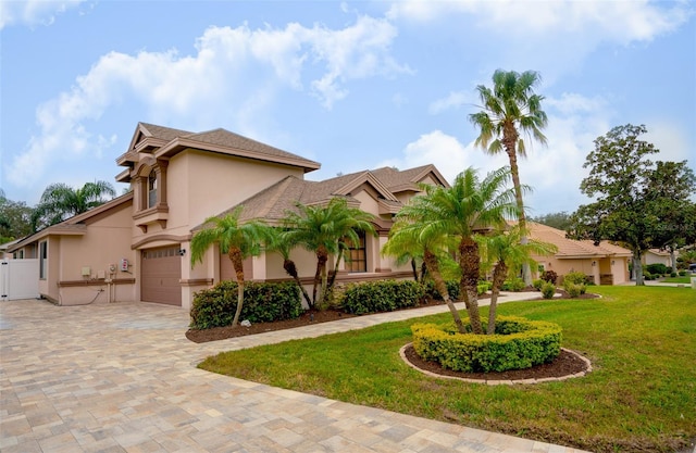 mediterranean / spanish-style house with a front lawn and a garage