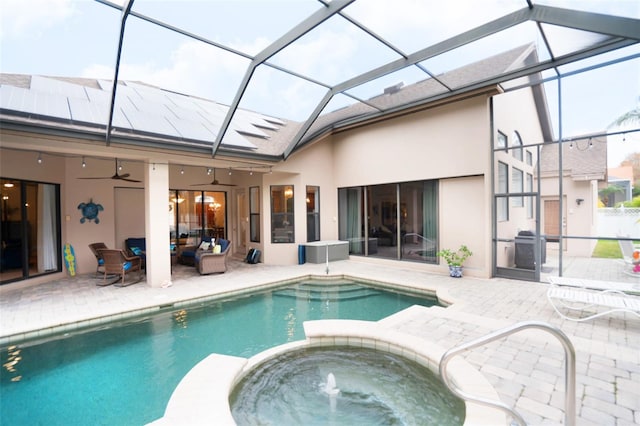 view of pool with an in ground hot tub, ceiling fan, a patio, glass enclosure, and outdoor lounge area