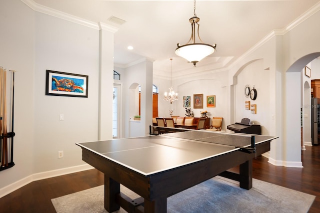 recreation room featuring ornamental molding, an inviting chandelier, and dark hardwood / wood-style floors