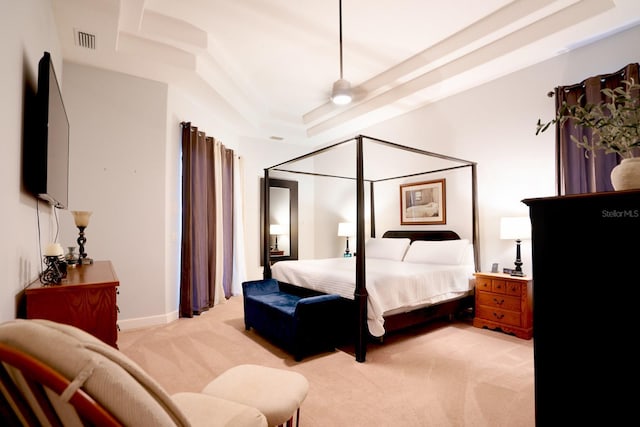 bedroom with a tray ceiling and light colored carpet