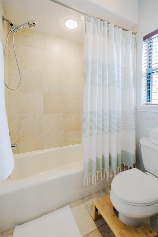 bathroom with toilet, tile patterned floors, and shower / bath combo with shower curtain