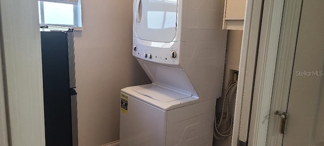 laundry area featuring stacked washer / drying machine