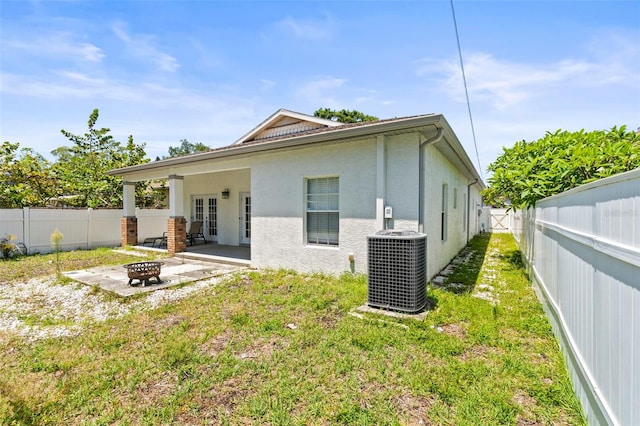 3611 19th St N, Saint Petersburg, FL 33713 - rear view of property with an outdoor fire pit, cooling unit, french doors, a patio area, and stucco siding